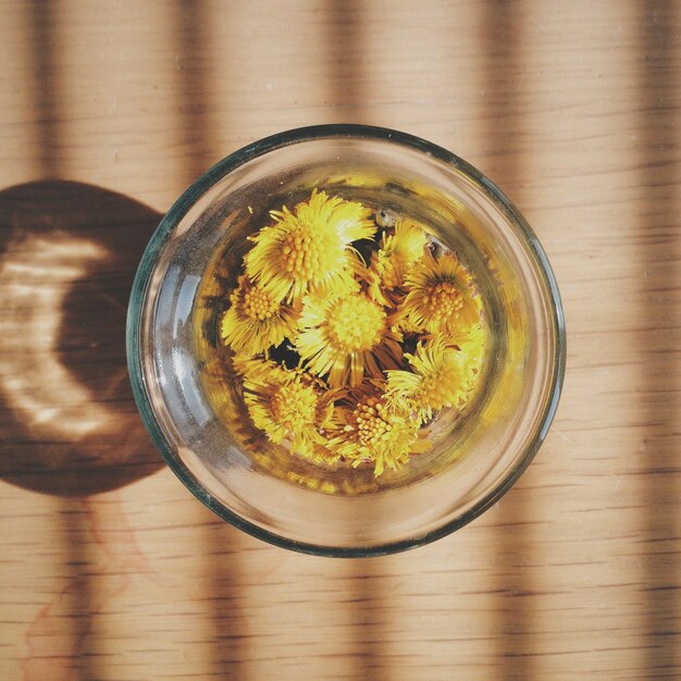 Photo des fleurs jaunes dans un verre à boire