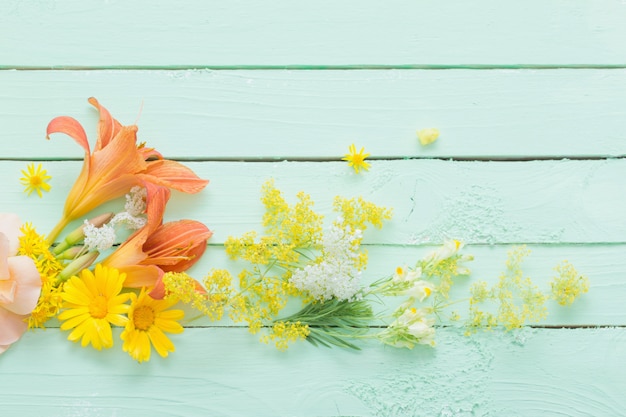 Fleurs jaunes et orange sur bois vert