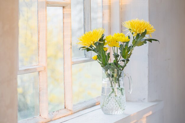 Fleurs jaunes sur rebord de fenêtre blanc