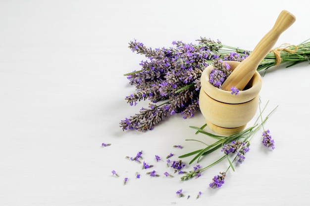 Fleurs de lavande séchées et dans le mortier en bois.