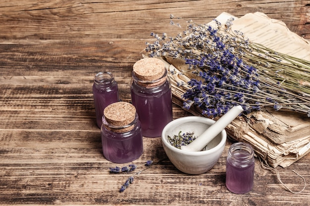 Fleurs de lavande séchées dans un mortier et pilon avec bouteille d'huile essentielle de lavande