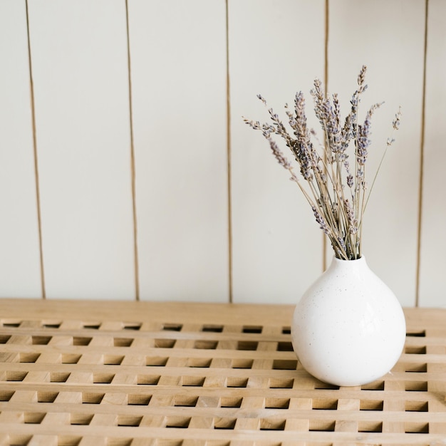 Fleurs de lavande séchées dans un vase minimaliste blanc dans le décor Espace de copie