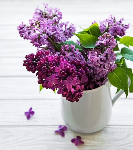 Fleurs lilas dans un vase sur une table en bois blanc