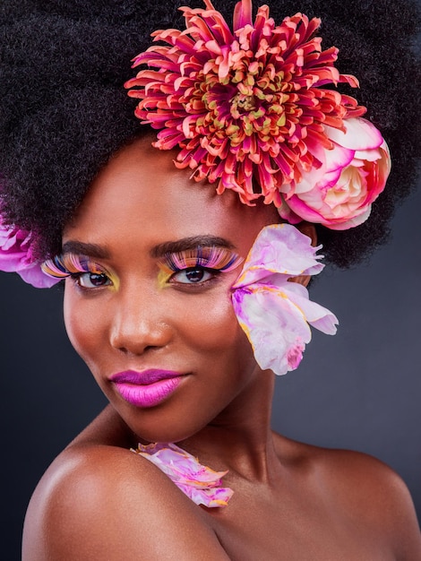 Photo fleurs de maquillage et art avec portrait de femme noire pour la beauté créative et printanière cosmétiques naturels et floraux avec visage de modèle isolé sur fond de studio pour l'amour de soi ou la confiance en couleur