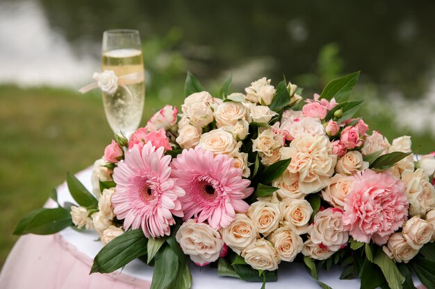 Fleurs de mariage et verre de champagne sur la table pour la cérémonie de mariage