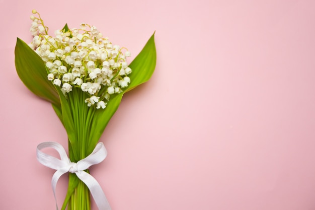 Fleurs de muguet sur fond rose