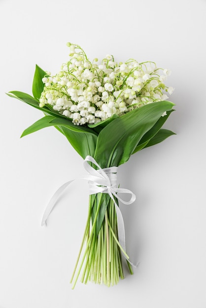 Fleurs de muguet isolées sur une surface blanche