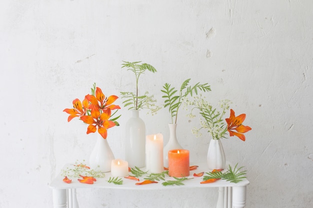Fleurs orange et bougies sur fond blanc