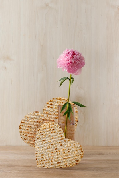 Fleurs de pivoine dans le vase et la matzah sous la forme d'un concept de fête juive de Pâque cardiaque