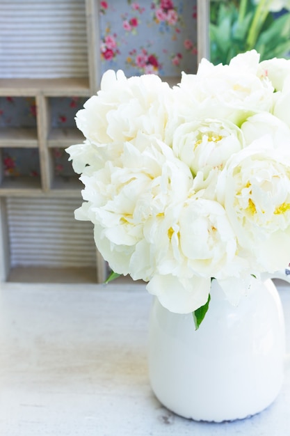 Fleurs de pivoine en fleurs fraîches blanches dans un vase sur la table