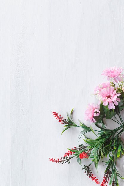 Fleurs à plat sur fond de bois blanc