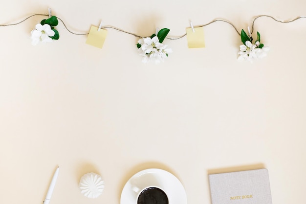 Fleurs de pommier blanches suspendues à une ficelle avec des pinces à linge en bois et des morceaux de papier pour les notes