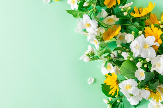 Fleurs printanières blanches et jaunes sur fond vert avec espace de copie.