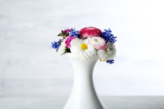 Fleurs printanières colorées sur fond de bois blanc