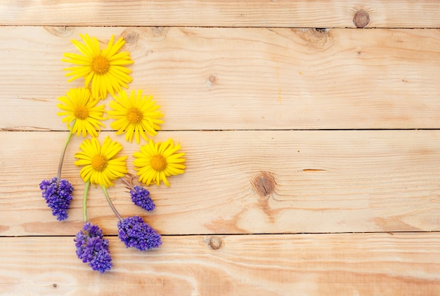 Les fleurs printanières jaunes sont disposées sur un fond en bois. Vue de dessus.