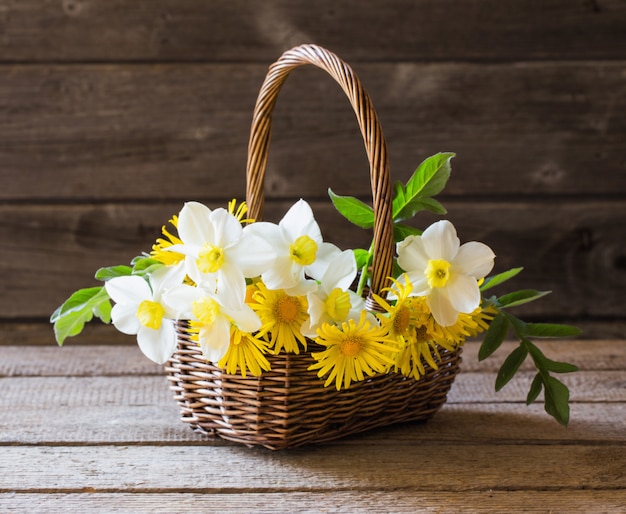 fleurs de printemps dans le panier sur la table en bois