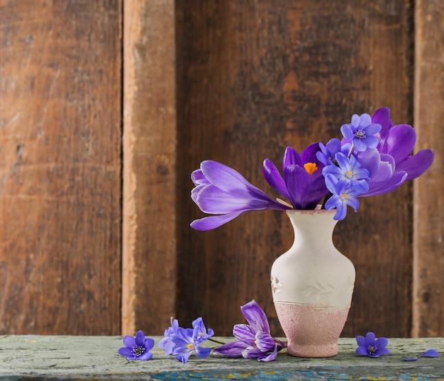 Photo fleurs de printemps dans un vase sur un espace en bois