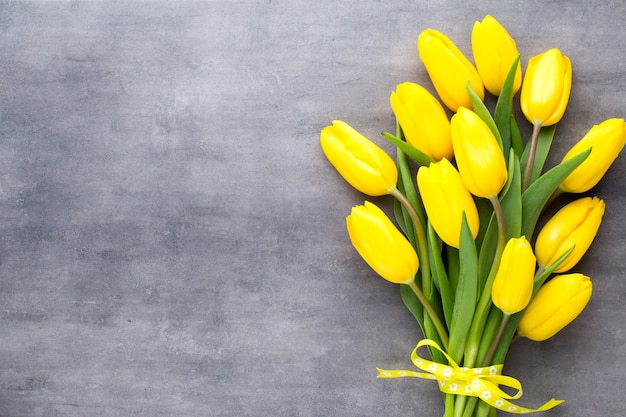 Fleurs de printemps jaune, tulipe sur fond gris.