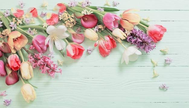 Fleurs de printemps sur une surface en bois verte