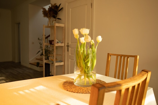 Fleurs de printemps tulipes blanches dans un vase en verre sur une table en bois