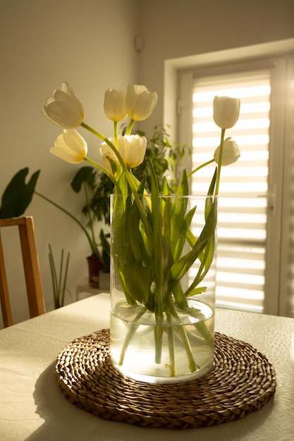 Fleurs de printemps tulipes blanches dans un vase en verre sur une table en bois