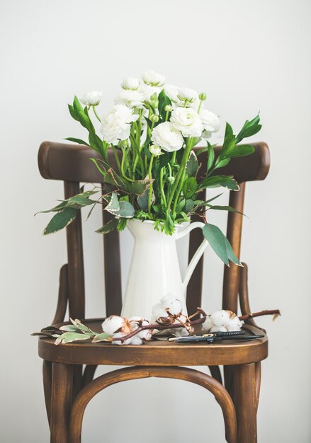 Fleurs de renoncule blanches de printemps dans une cruche en émail blanc