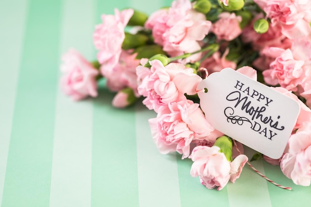 Fleurs roses pour la fête des mères sur papier à rayures.