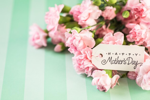 Fleurs roses pour la fête des mères sur papier à rayures.