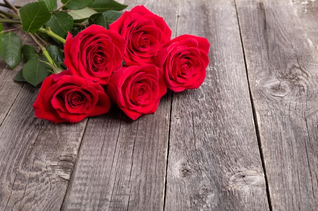 Fleurs roses rouges sur table en bois gris. Carte de voeux. Copier l'espace pour le texte - Image