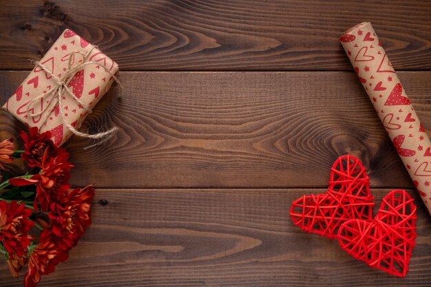 Fleurs rouges et un cœur sur planche de bois. Fond de Saint Valentin. Carte de Saint Valentin avec espace copie pour le texte.