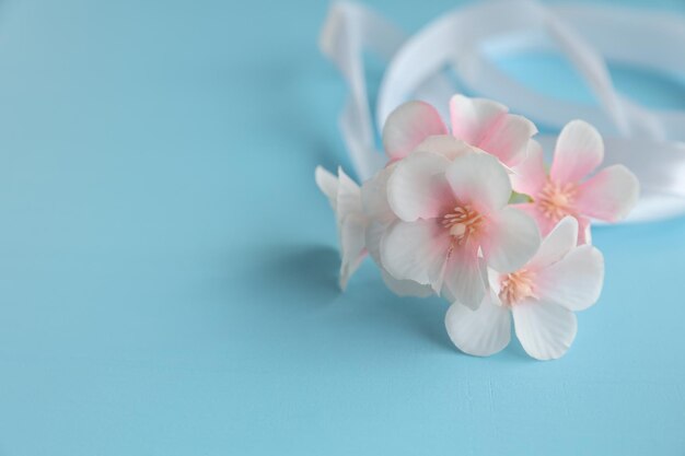 Fleurs avec ruban blanc sur fond bleu