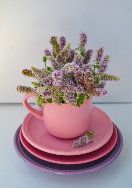 fleurs sauvages dans la tasse rose pour l'heure du thé et beau fond