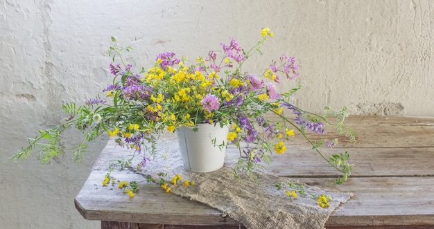 Fleurs sauvages d'été sur la vieille table en bois