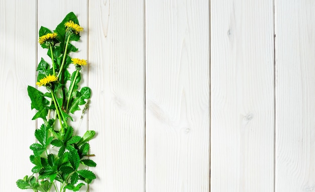 Fleurs sauvages de printemps sur une surface blanche en bois