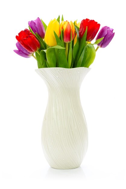 Fleurs de tulipes multicolores fraîches dans un vase isolé sur fond blanc