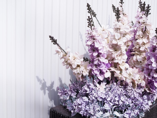 Fleurs violettes contre mur en bois blanc