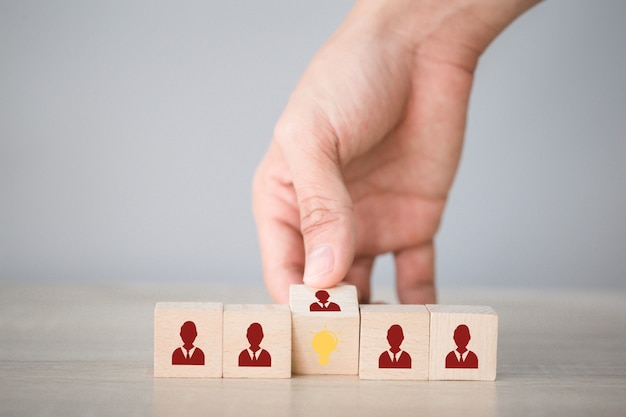 Photo flips de main cube avec icône ampoule et symbole humain, idée créative et concept d'innovation.