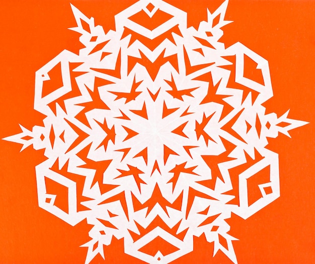 Flocon de neige blanc sur papier orange