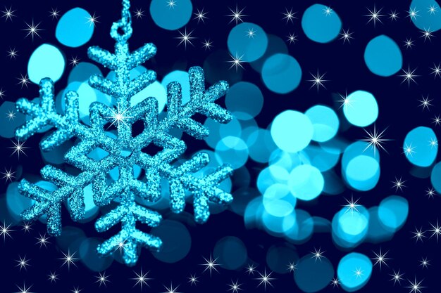 Flocon de neige de décoration de Noël sur fond de lumières et d'étoiles défocalisées