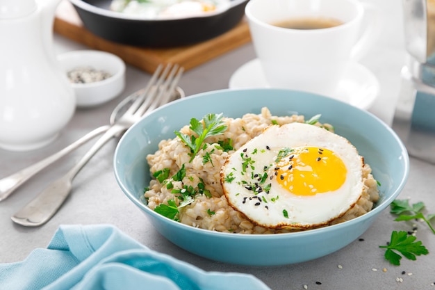 Flocons d'avoine salés avec des œufs frits au plat pour le petit-déjeuner