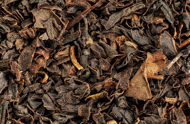 Flocons bruns de thé noir en vrac - variété indienne. Feuilles sèches sous microscope à grossissement 1,5x - largeur d'image 23mm
