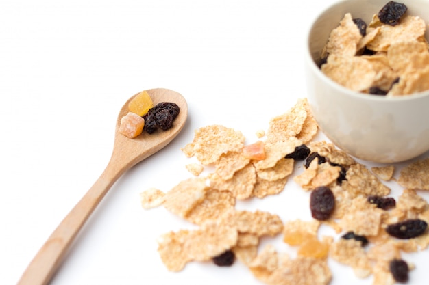 Flocons de céréales à grains entiers fruits et raisins secs pour le petit déjeuner isolé sur fond blanc