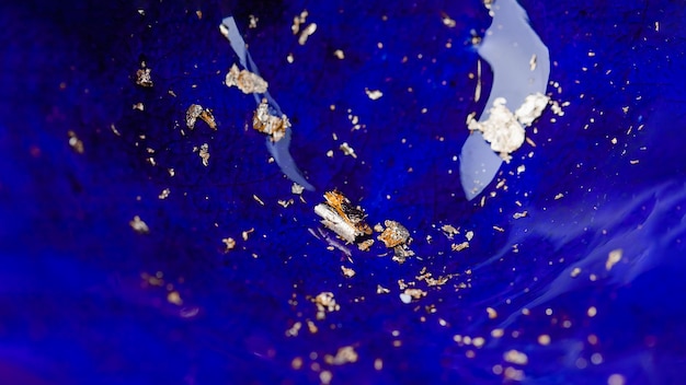Flocons de métal en feuille d'or sur fond de panorama en émail céramique bleu