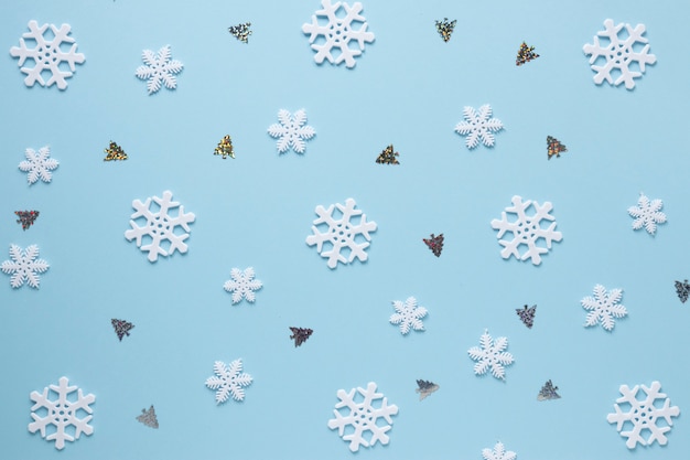 Flocons de neige et arbres de Noël sur fond bleu
