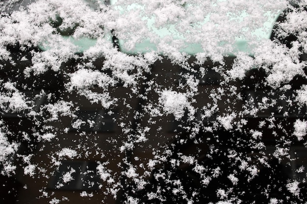 Flocons de neige blancs sur fond ou texture de surface noire