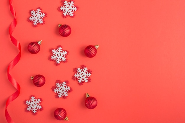 Flocons de neige et boules sur la surface rouge