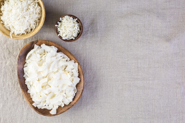 Flocons de noix de coco déshydratés dans un bol en bois.