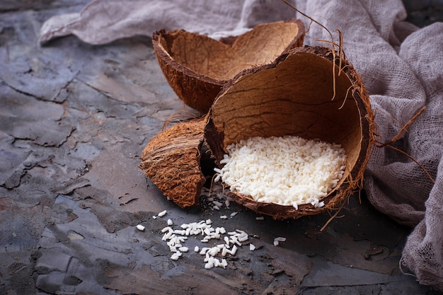 Flocons de noix de coco fraîche sur fond gris