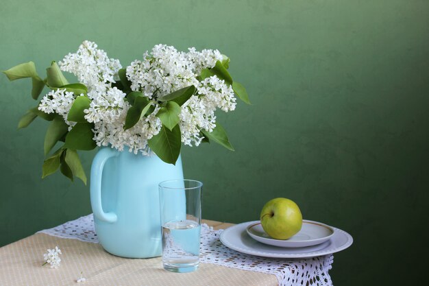 Floraison de lilas blanc dans un pot, un bouquet de fleurs dans un vase.