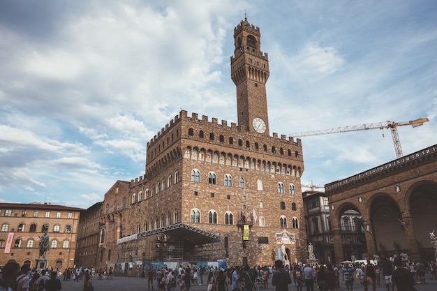 Florence, Italie - 24 juin 2018 : Vue panoramique du Palazzo Vecchio (vieux palais) est l'hôtel de ville de Florence. Les gens marchent sur la Piazza della Signoria en journée d'été